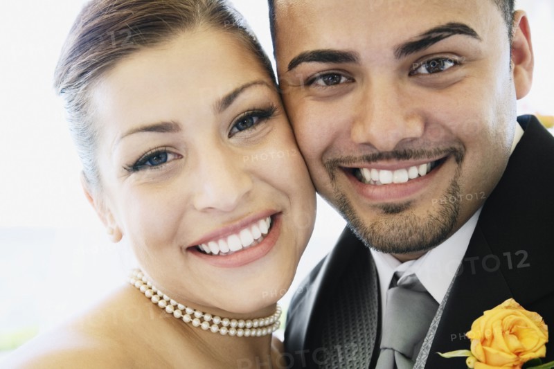 Multi-ethnic bride and groom hugging
