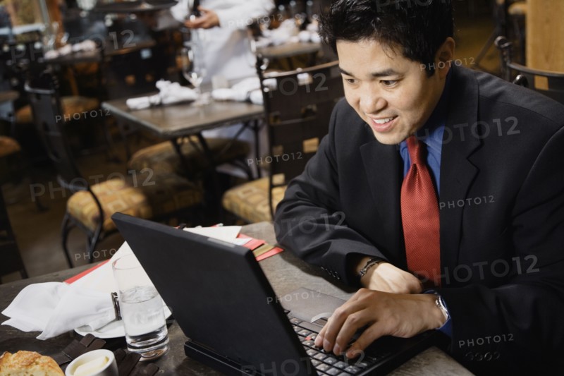 Asian businessman typing on laptop