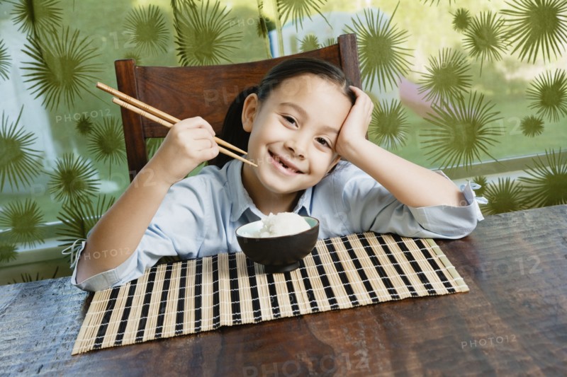 Asian girl eating bowl of rice
