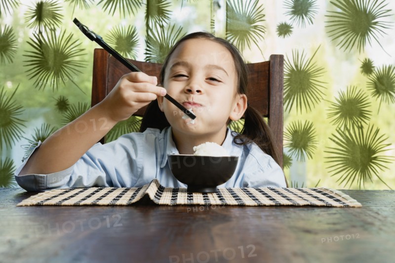 Asian girl eating bowl of rice
