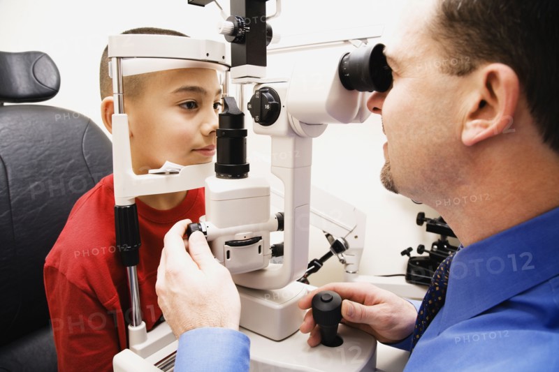Asian boy having eyes examined