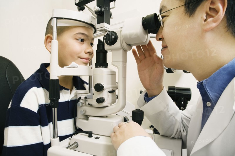 Asian male optometrist examining patient