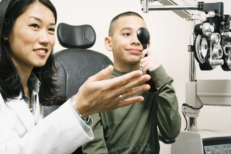Asian female optometrist examining patient