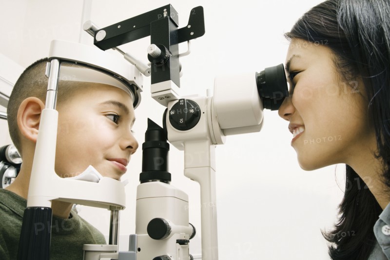 Asian female optometrist examining patient