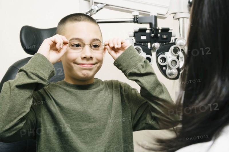 Asian boy trying on eyeglasses