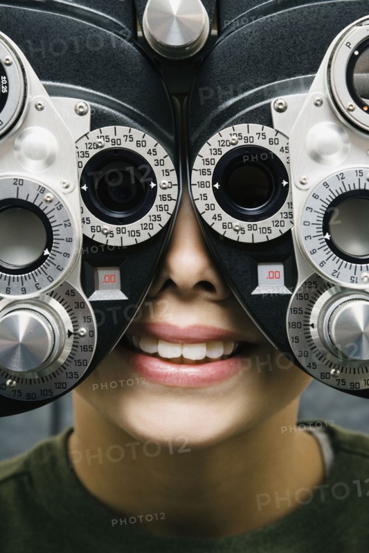 Asian boy having eyes examined
