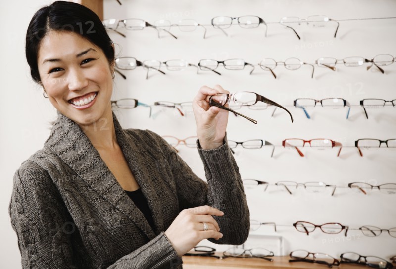 Asian woman holding eyeglasses