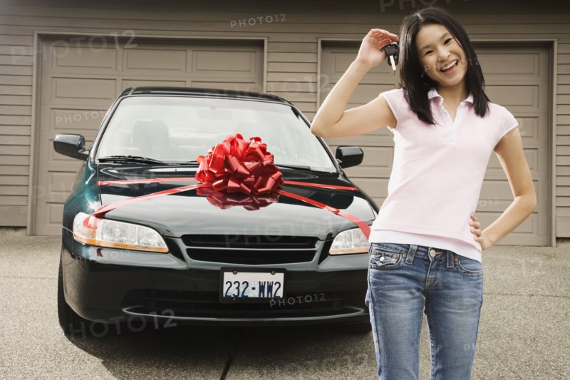 Asian teenager with keys to new car