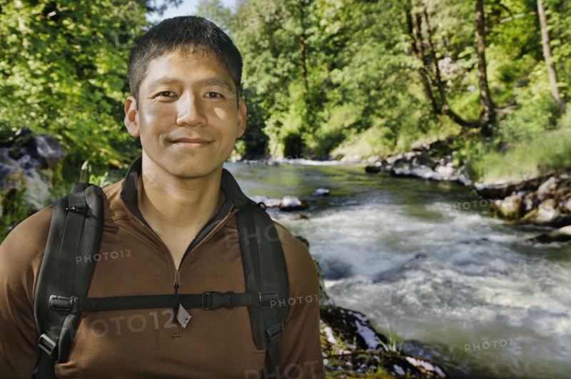Mixed race man hiking near river