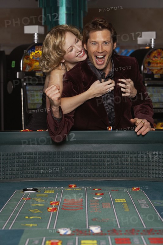 Woman hugging her successful boyfriend at a casino