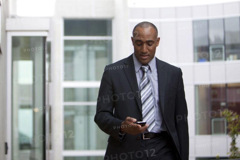 Mixed race man looking at cell phone