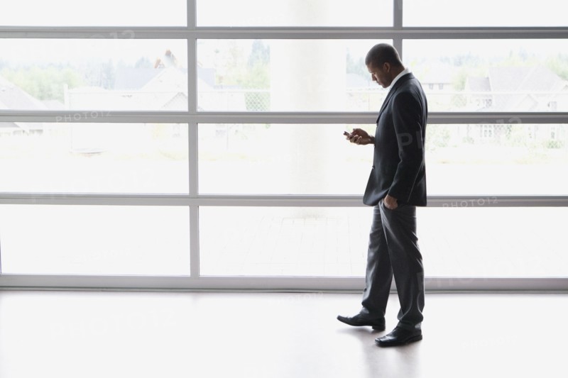 African businessman text messaging on cell phone