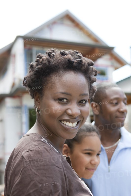 Family standing near house under construction