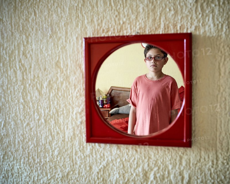 Hispanic boy admiring himself in mirror