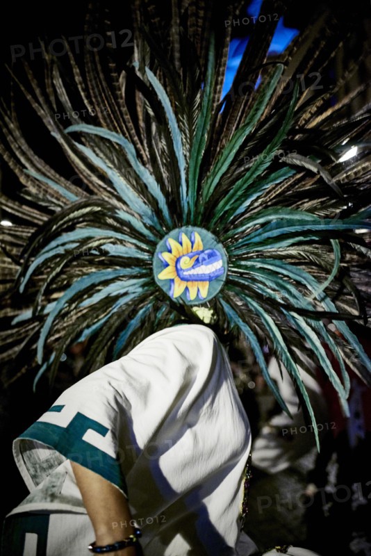 Dancer wearing feather headdress in performance