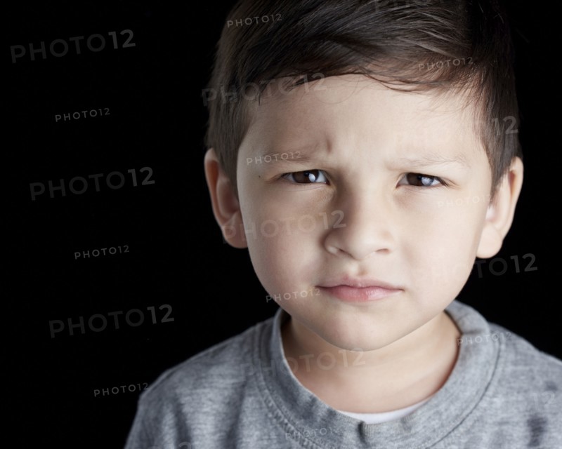 Close up of Hispanic boy frowning