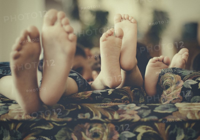 Close up of feet of children on sofa