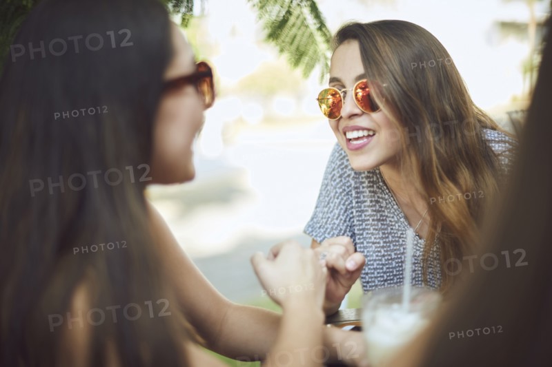 Smiling Hispanic women wearing sunglasses