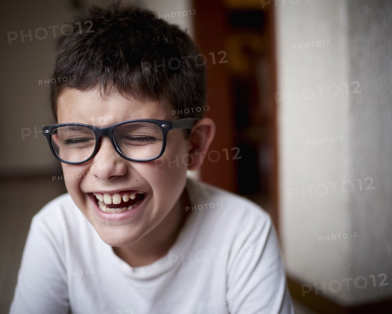 Laughing Hispanic boy wearing eyeglasses