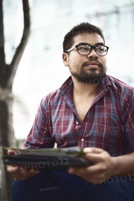 Hispanic man sitting outdoors