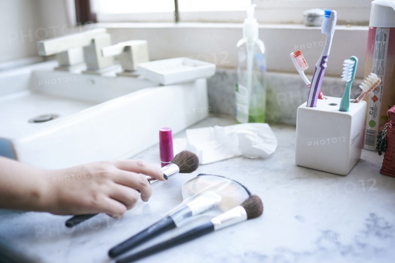 Hand of Hispanic woman holding makeup brush