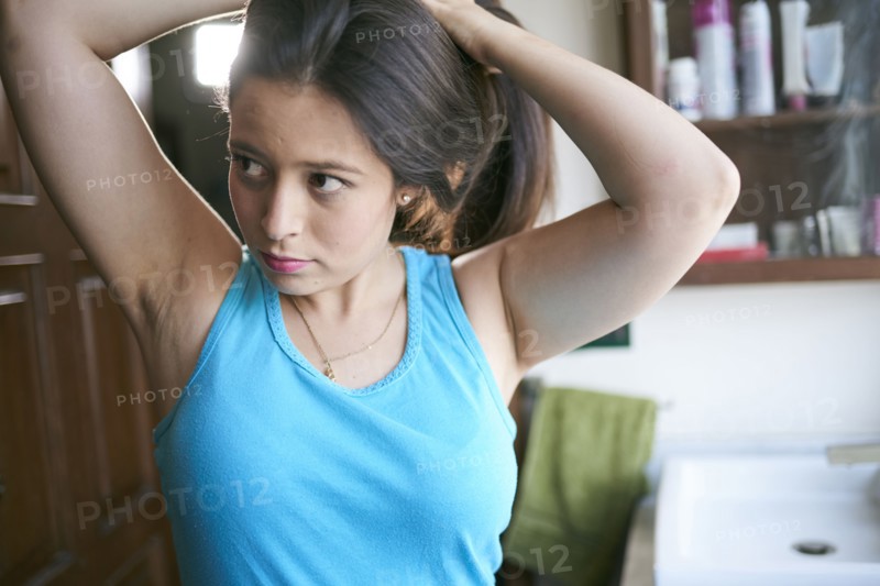 Hispanic woman lifting hair