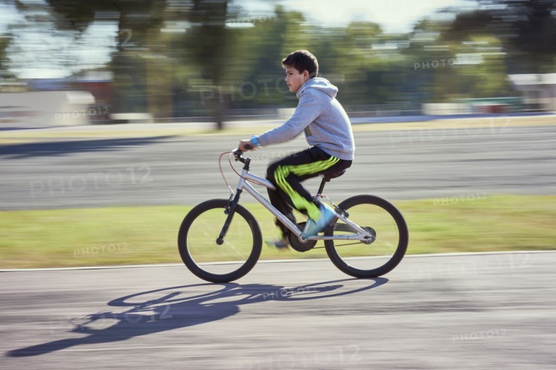 Hispanic boy riding bicycle