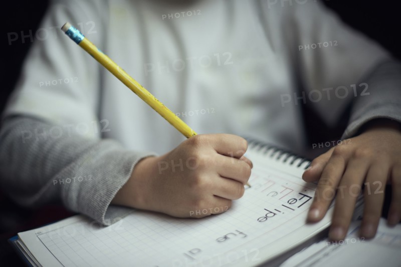 Hispanic boy practicing writing alphabet