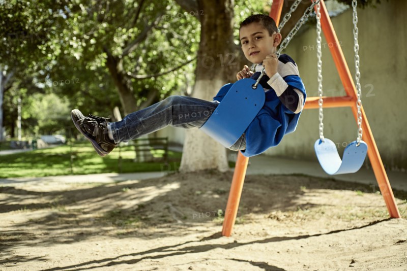 Hispanic boy on swing at park