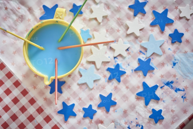 Paintbrushes and blue stars on table