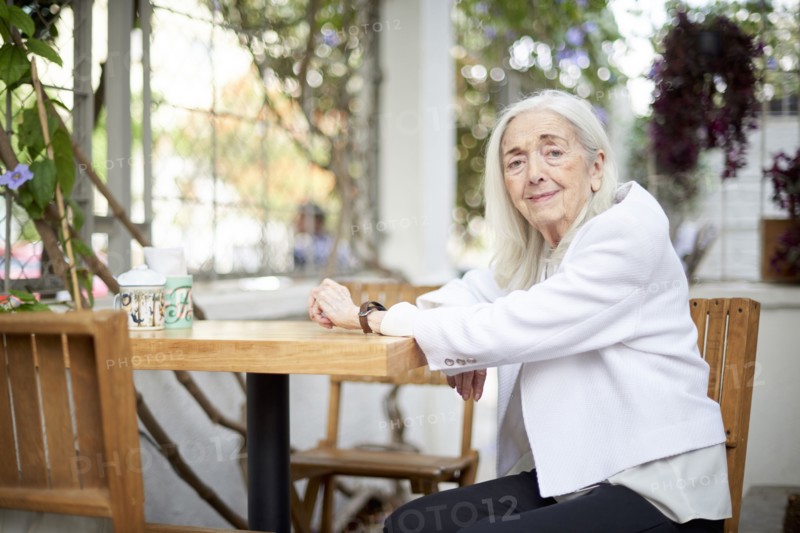 Portrait of smiling older Caucasian woman sitting at table