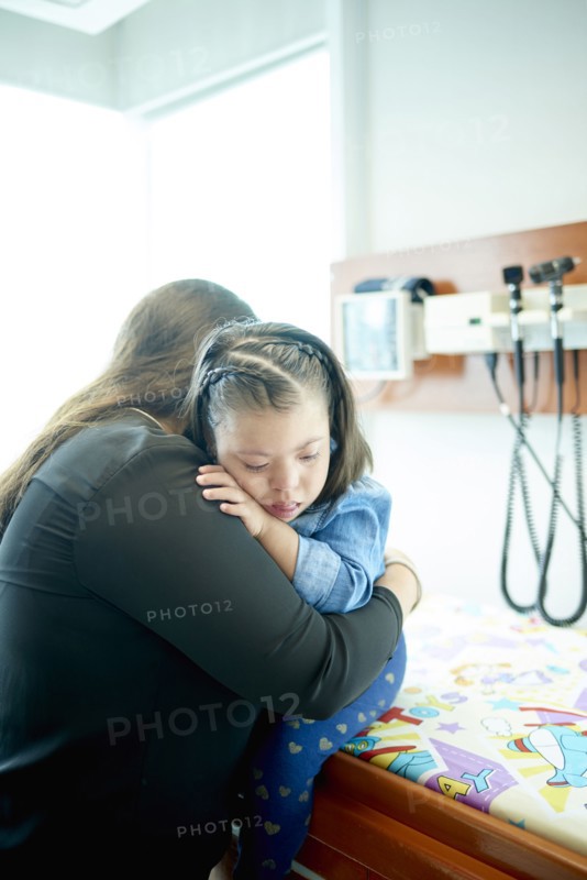 Hispanic mother hugging daughter with Down Syndrome
