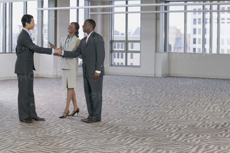 Multi-ethnic business people handshaking in empty building