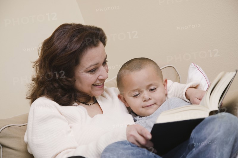 Multi-ethnic grandmother and grandson reading book