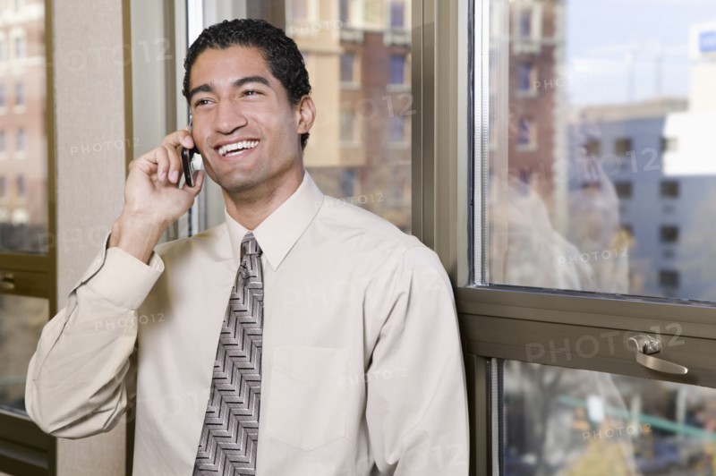 Mixed race businessman talking on cell phone