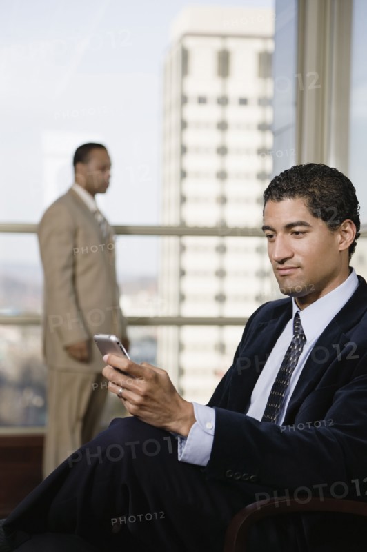 Mixed race businessman using cell phone