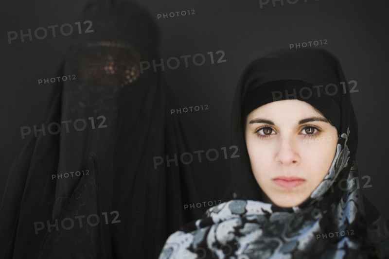 Middle Eastern woman in burka and teenager in headscarf