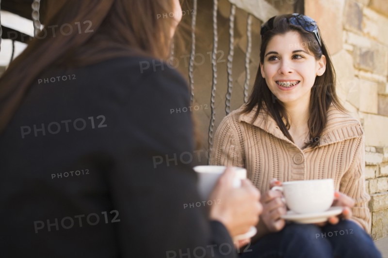 Middle Eastern mother and daughter drinking coffee