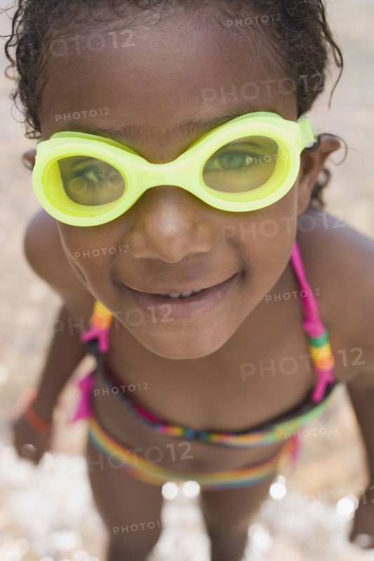 Smiling African girl wearing goggles and bikini