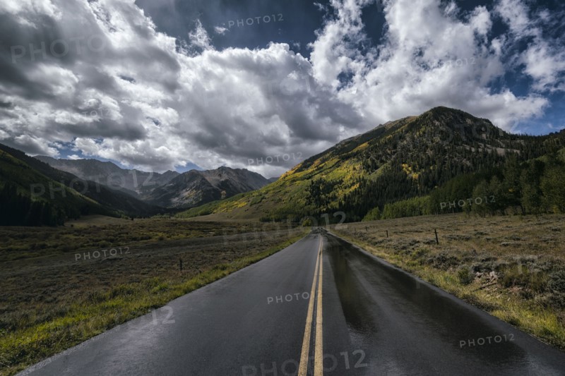 Wet two-lane road near mountains
