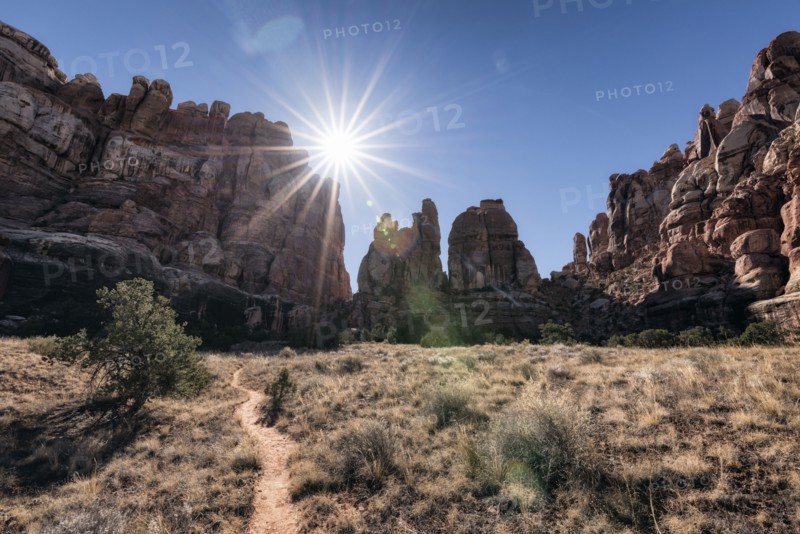 Sun in blue sky over desert path