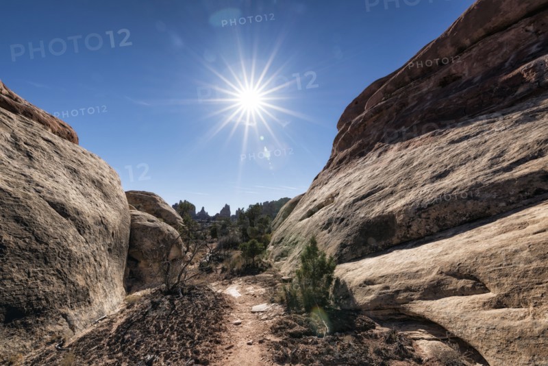 Sun in blue sky over desert path