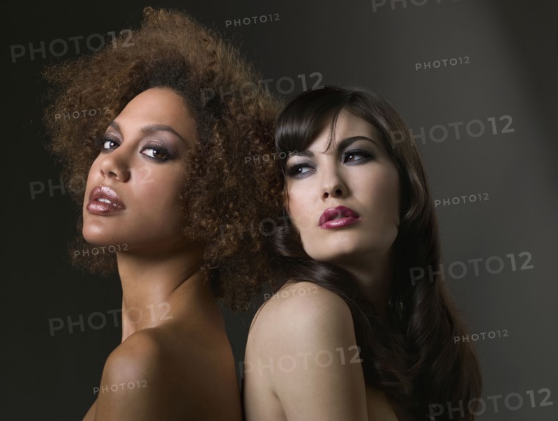 Mixed Race women with bare shoulders standing back to back
