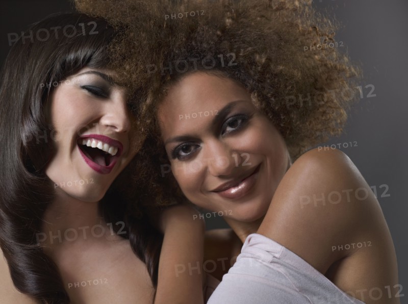 Mixed Race women hugging and laughing