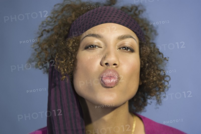 Mixed Race woman blowing kiss