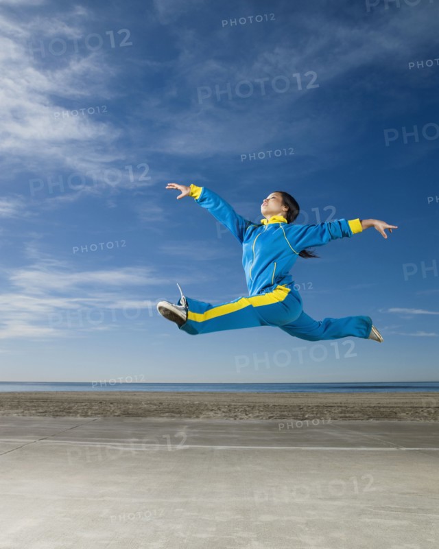Asian woman jumping in air