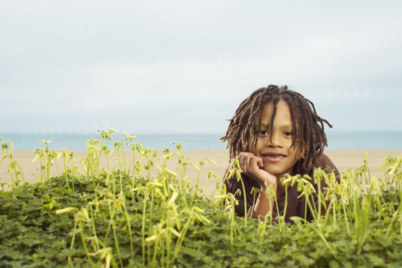 Mixed Race boy laying in plants