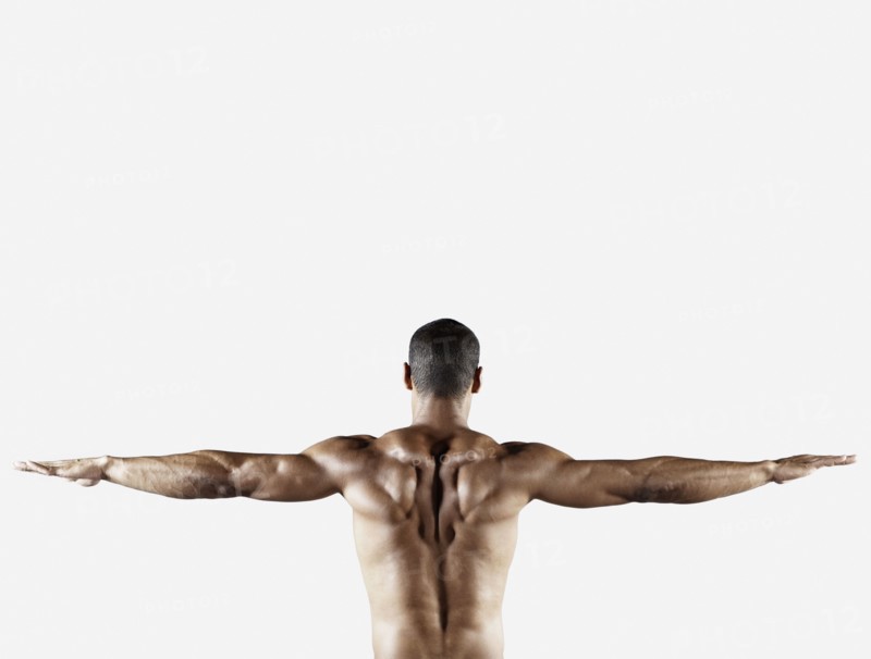 Bare chested mixed race man with arms outstretched