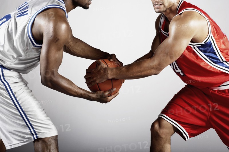 Basketball player trying to take basketball from opponent