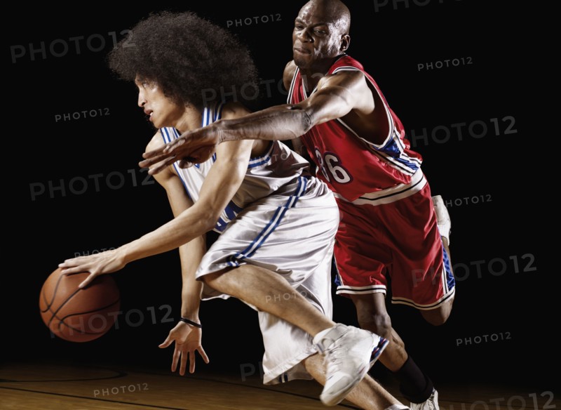 Basketball player trying to take basketball from opponent